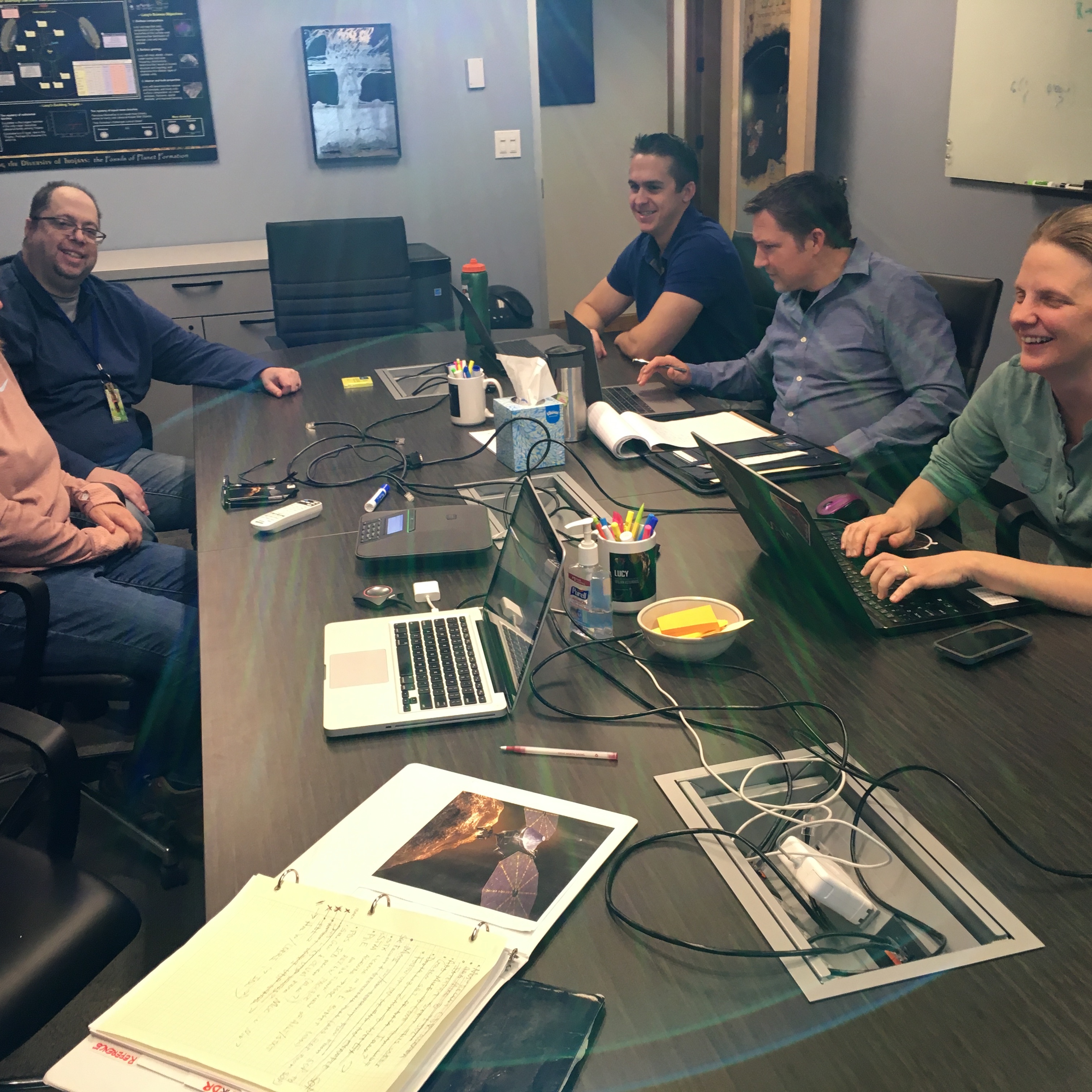 The weekly Lucy Science Operations Center meeting to discuss the flow of bits: uplink (planning and sequencing observations) and downlink (processing and distributing the data).  From left to right: Cathy Olkin (SwRI), Anthony Egan (SwRI), Zach Talpas (Stellar Solutions), Jon Pineau (Stellar Solutions), Emma Birath (SwRI).
