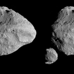 Two slightly different perspectives of Dinkinesh (diamond-shaped asteroid) and Selam (small, to the bottom left of Dinkinesh), one on the left side of the image, the other on the right. It is lit from the right.